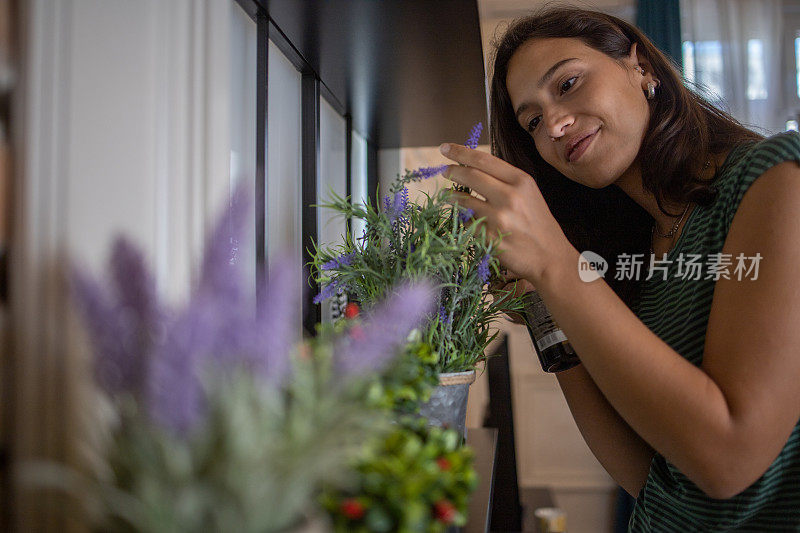 年轻女子在她的新公寓里照料植物