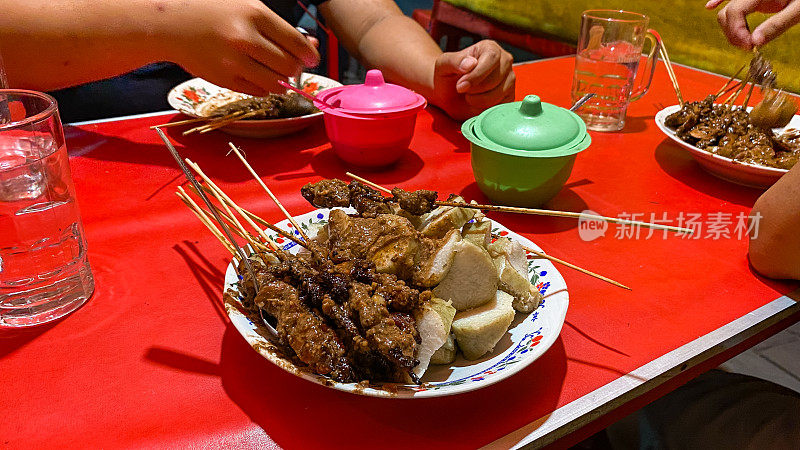 年轻的印尼男子吃沙爹鸡