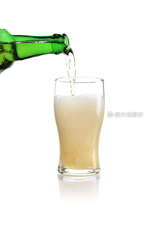 从绿瓶子中垂直喷出的啤酒倒入玻璃杯中