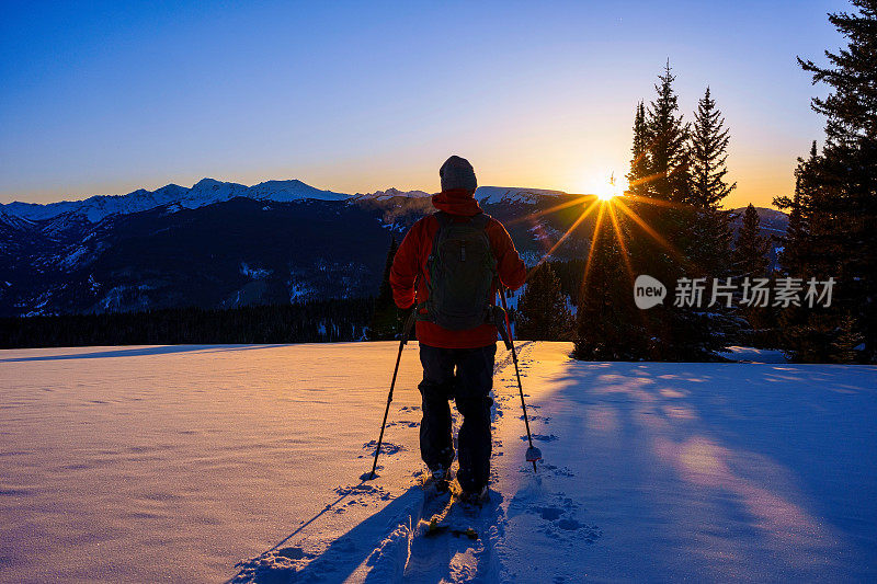 户外探险滑雪旅游与风景秀丽的山背景