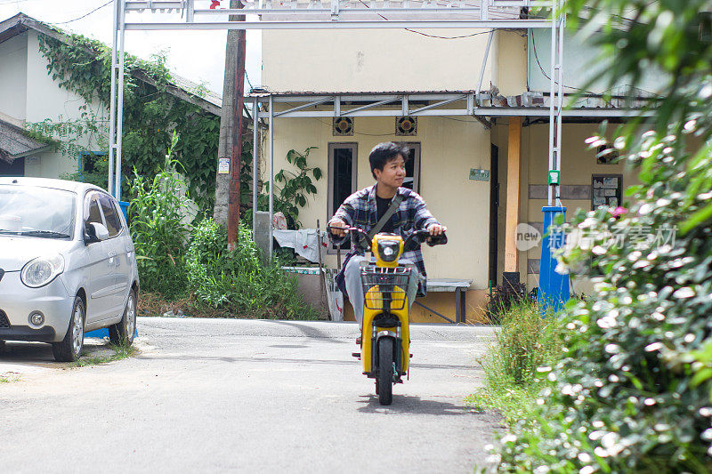 在居民区骑电动自行车的年轻人