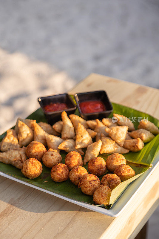 马尔代夫小吃，油炸手指食物，金枪鱼球，古拉和巴吉雅在海滩上的茶时间