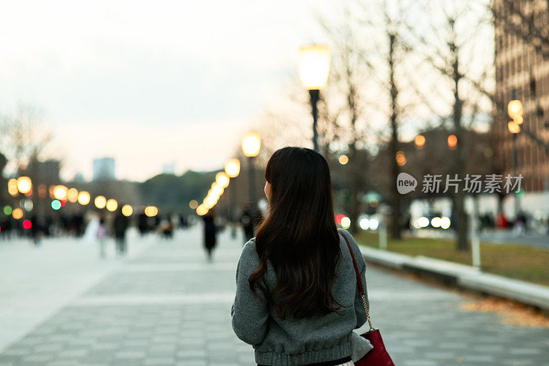 美丽的年轻女子享受夜晚的城市风景