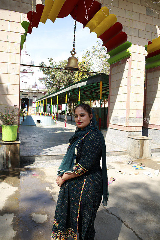 美丽的印度妇女站在印度教寺庙门口