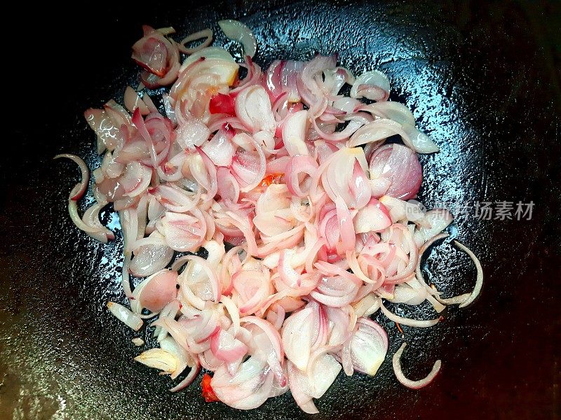 用煎锅煎碎红洋葱。