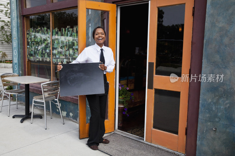 非裔美国女招待站在餐厅外，脸上一片空白