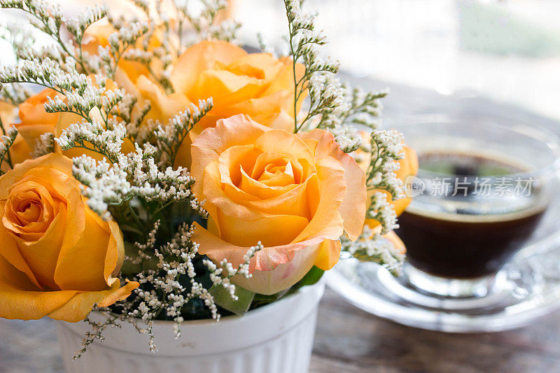 桌上有玫瑰，背景是咖啡，柔焦