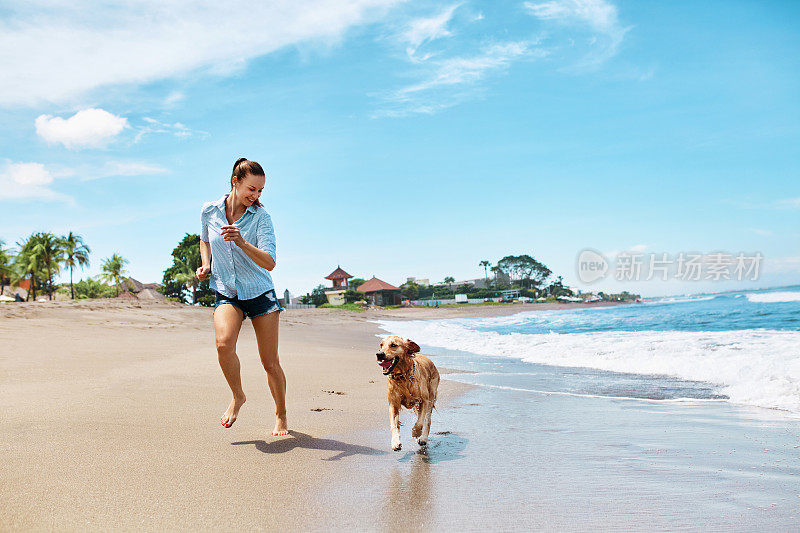 夏天海滩乐趣。带着狗跑的女人。节日假期。夏天