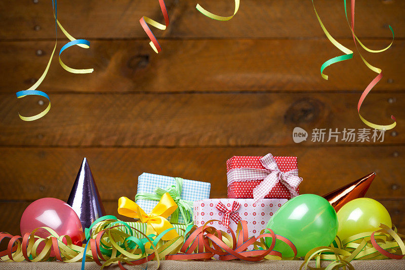 生日派对:礼物-气球和彩带，木制背景