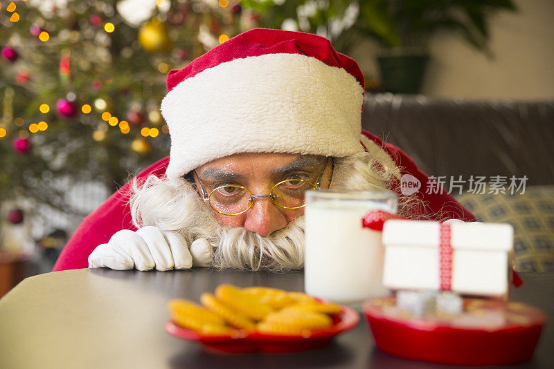 圣诞老人看着饼干和一杯牛奶