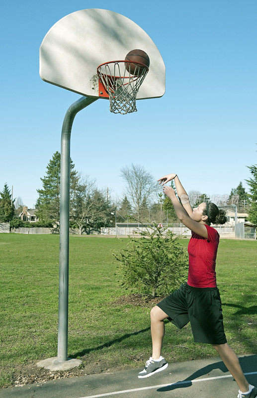 年轻女子在城市公园练习篮球