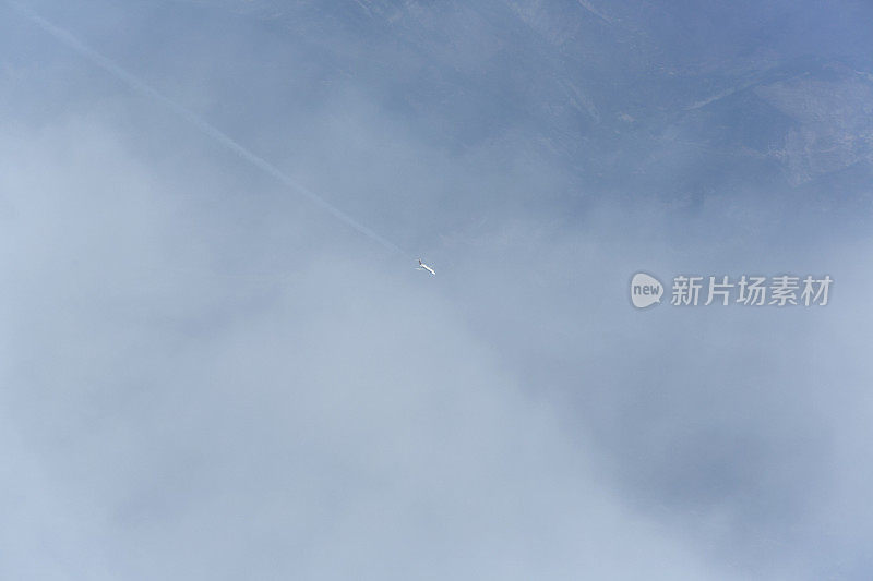在意大利，一架小飞机飞过云层进入天空