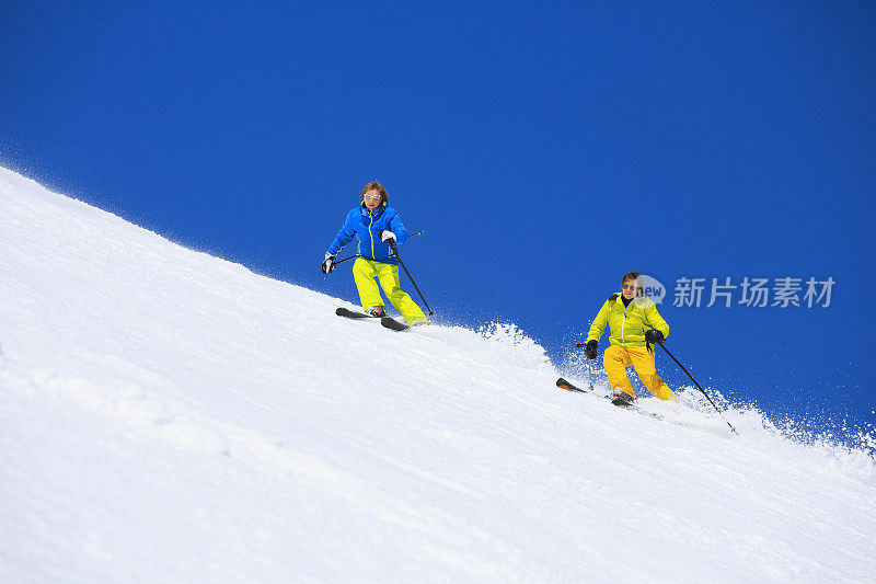 两个男人在阳光明媚的滑雪胜地滑雪