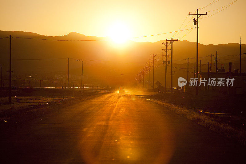 夕阳西下，汽车在路上行驶