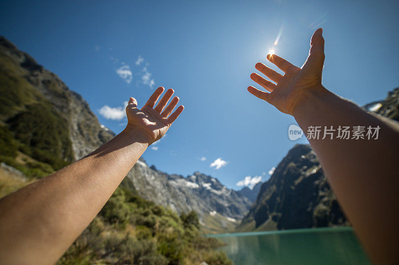 个人视角的女人的双臂伸向山湖