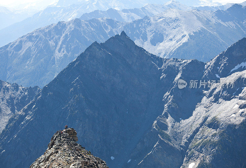 在珀塞尔山脉的遥远山峰上的徒步旅行者