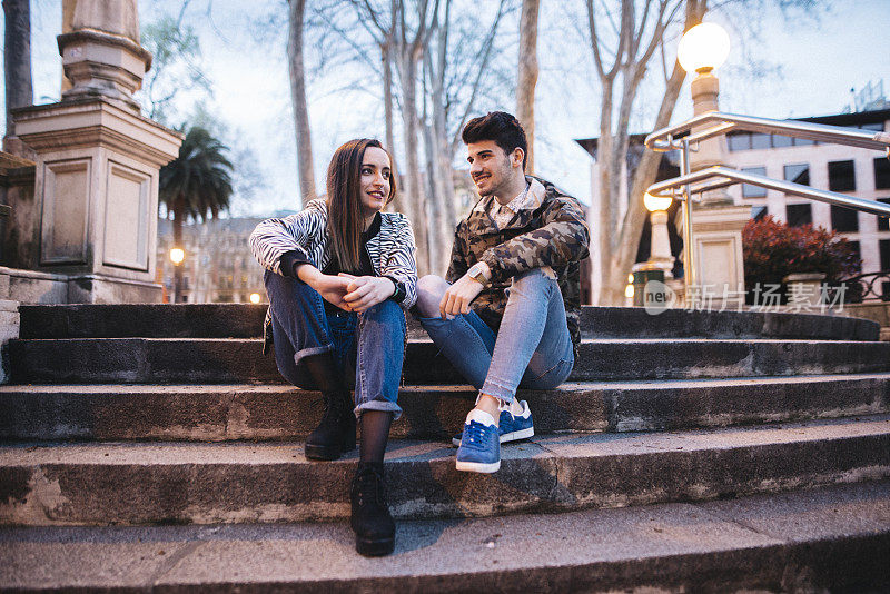 一对年轻夫妇在公园里坐着聊天