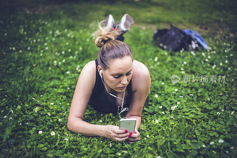 年轻女子在公园里听音乐