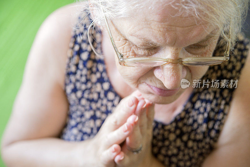 一位年长妇女在祈祷过程中的肖像