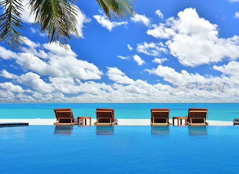 热带海滩度假村游泳池旁的日光浴床