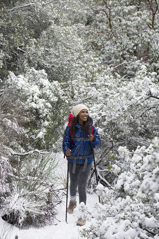 女人在下雪的天气徒步旅行。