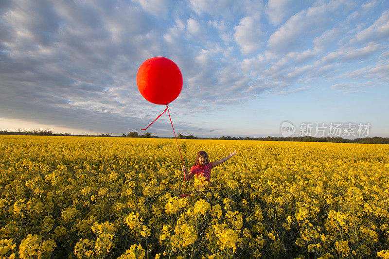 快乐的孩子在油菜籽田的气球