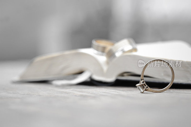 订婚戒指，两个结婚戒指和圣经。