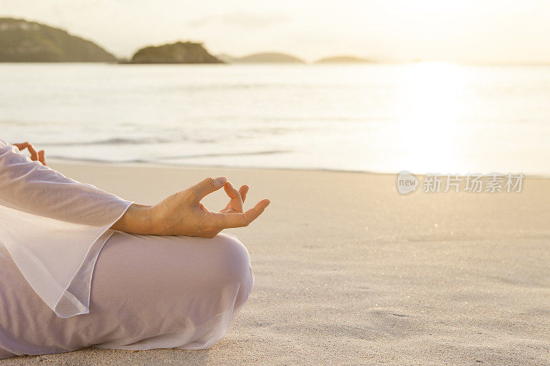 在加勒比海海滩上，一个在夕阳下沉思的不可辨认的女人