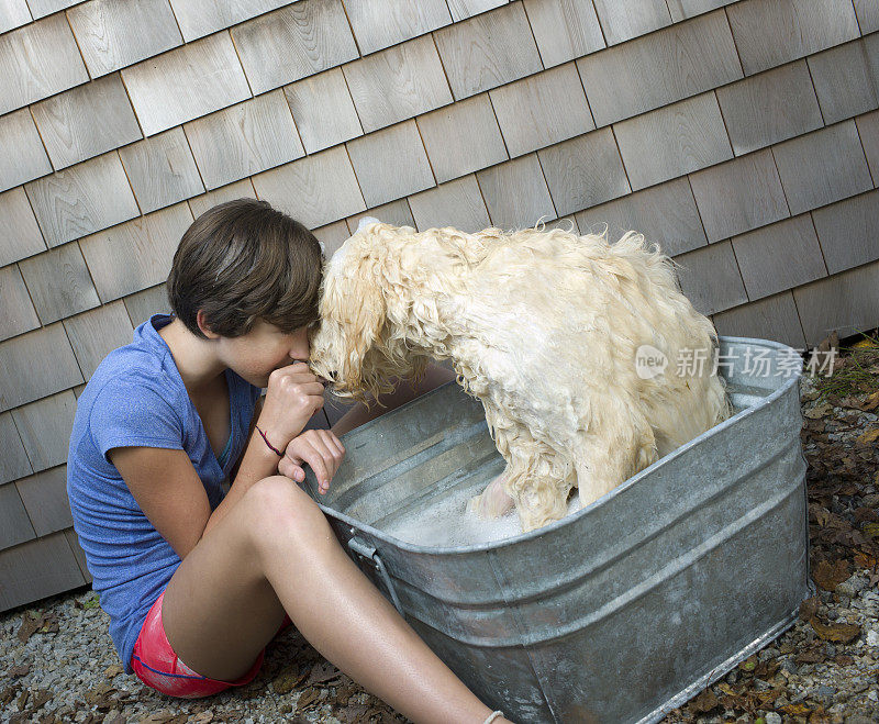 小女孩给她的狗洗澡。