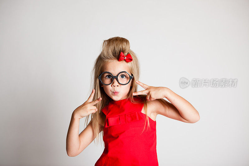 年轻女孩摆姿势在白色背景与眼镜