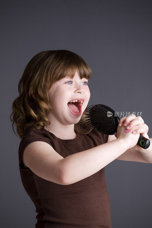 缺门牙的小女孩用梳子唱歌