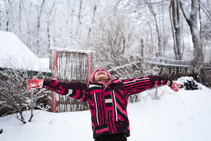 可爱的小女孩在下雪的时候张开双臂