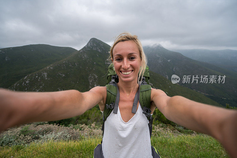 一名年轻女子在与山景自拍