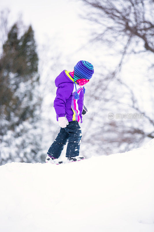 冬天在雪堆上行走的女孩