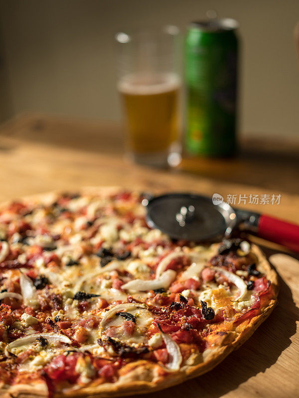 木桌上放着自制披萨和啤酒