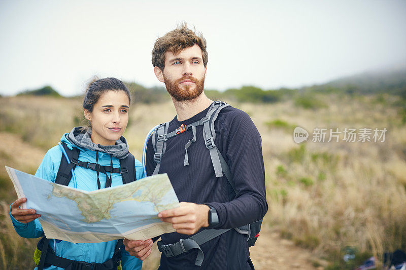 深思熟虑的徒步旅行者拿着地图对着天空