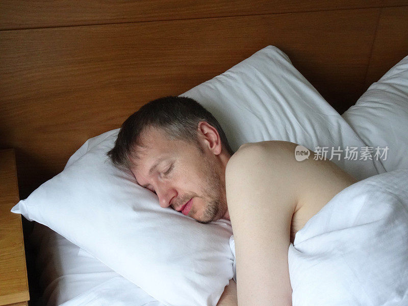 裸体男人睡在床上，呼呼大睡，胡子拉碴