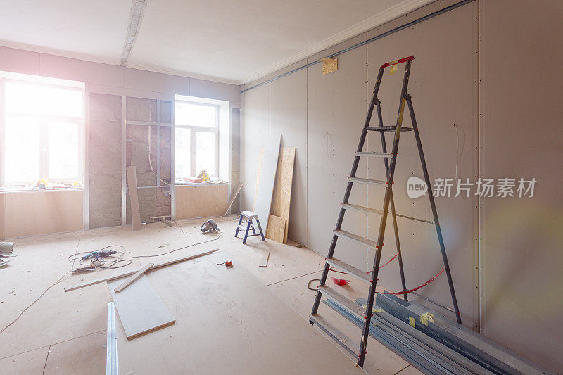 公寓在施工、改建、翻新、扩建、修复和改建过程中的内部——房间内的梯子和建筑材料
