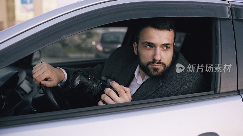 年轻私家侦探坐在车里，用单反相机拍照