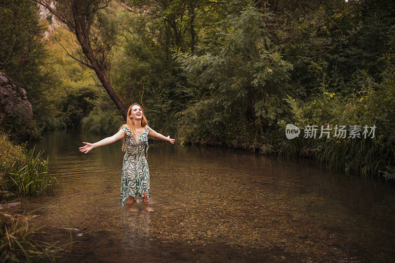 幸福的女人举起双臂享受生活