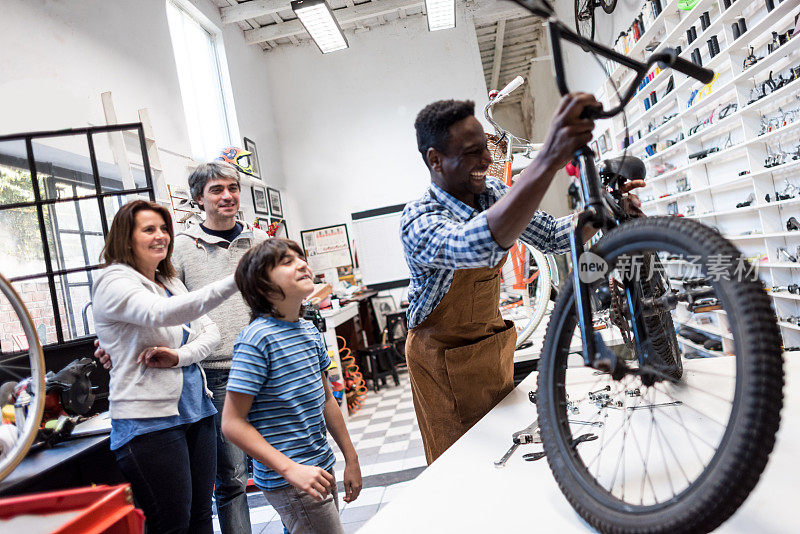 一名黑人销售员正在组装一对夫妇为他们的儿子买的新自行车