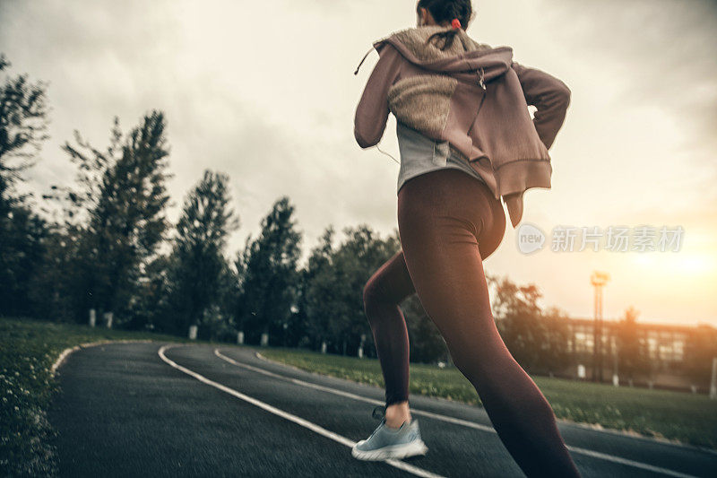 在体育场跑道上跑步的女人