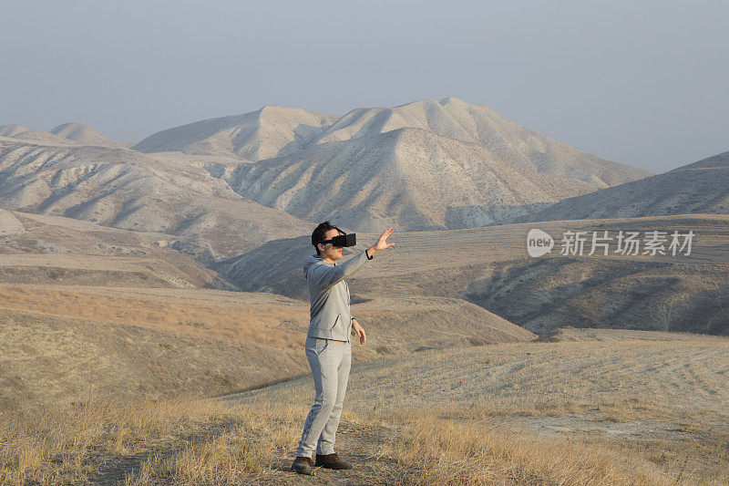 带着3D眼镜独自在极端地形中行走的年轻人