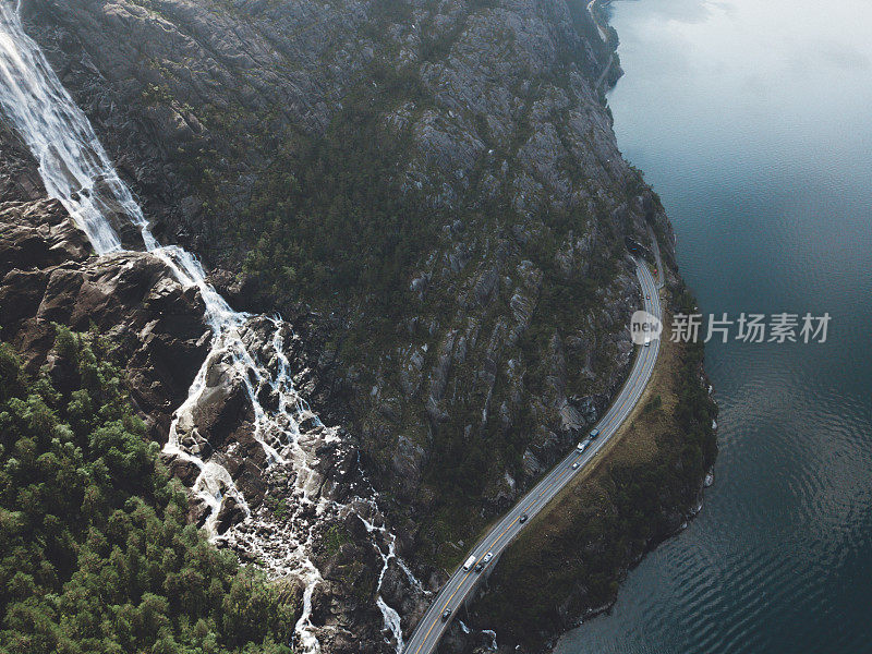 鸟瞰图，巨大的瀑布落入挪威的绿松石湖和道路