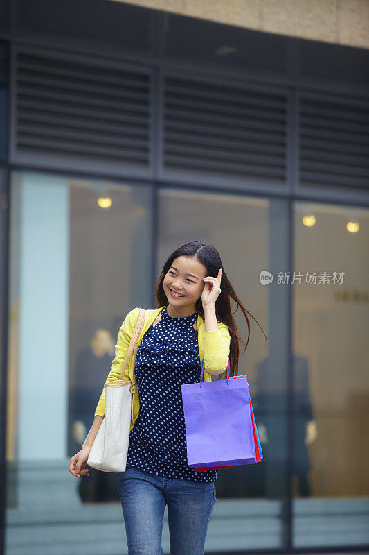 一个年轻漂亮的女人在街上购物