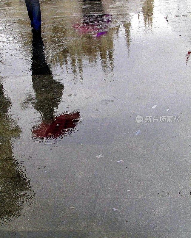 走在雨中，撑着一把红伞，倒影万千
