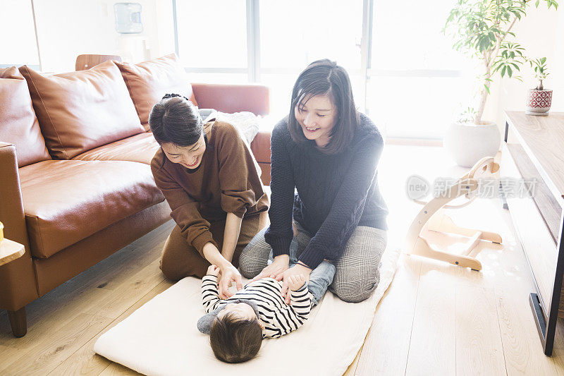 两个女人在客厅给男婴按摩