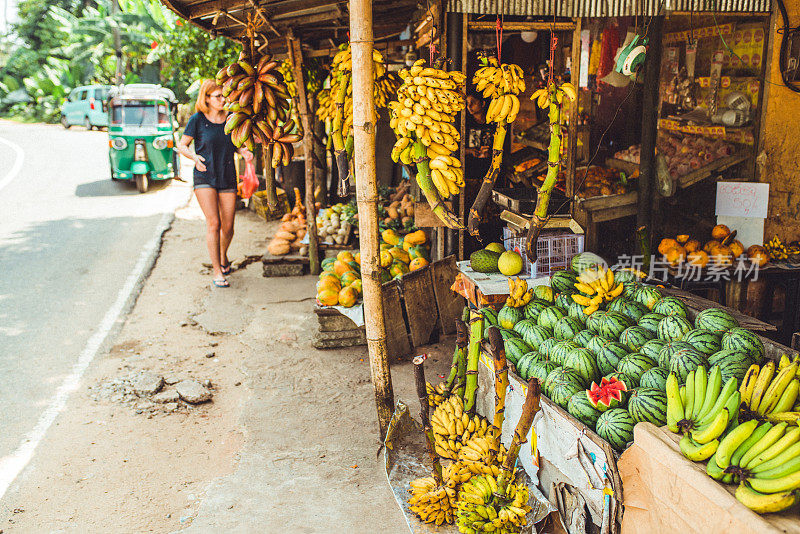 游客在斯里兰卡的市场摊位上浏览当地水果
