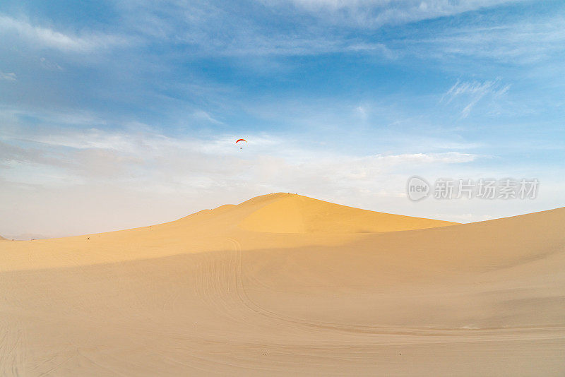 在秘鲁瓦卡奇纳的沙丘上跳伞。