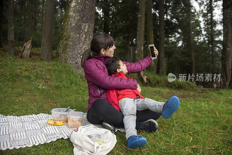 妈妈和儿子在树林里拍照